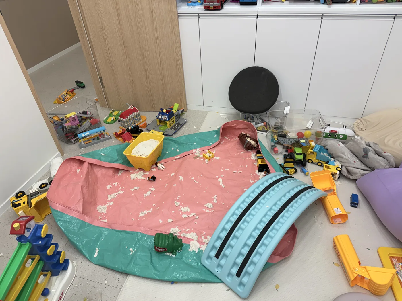 수업이 끝난 뒤 장난감과 모래놀이 재료가 온 바닥에 흩어진 놀이실