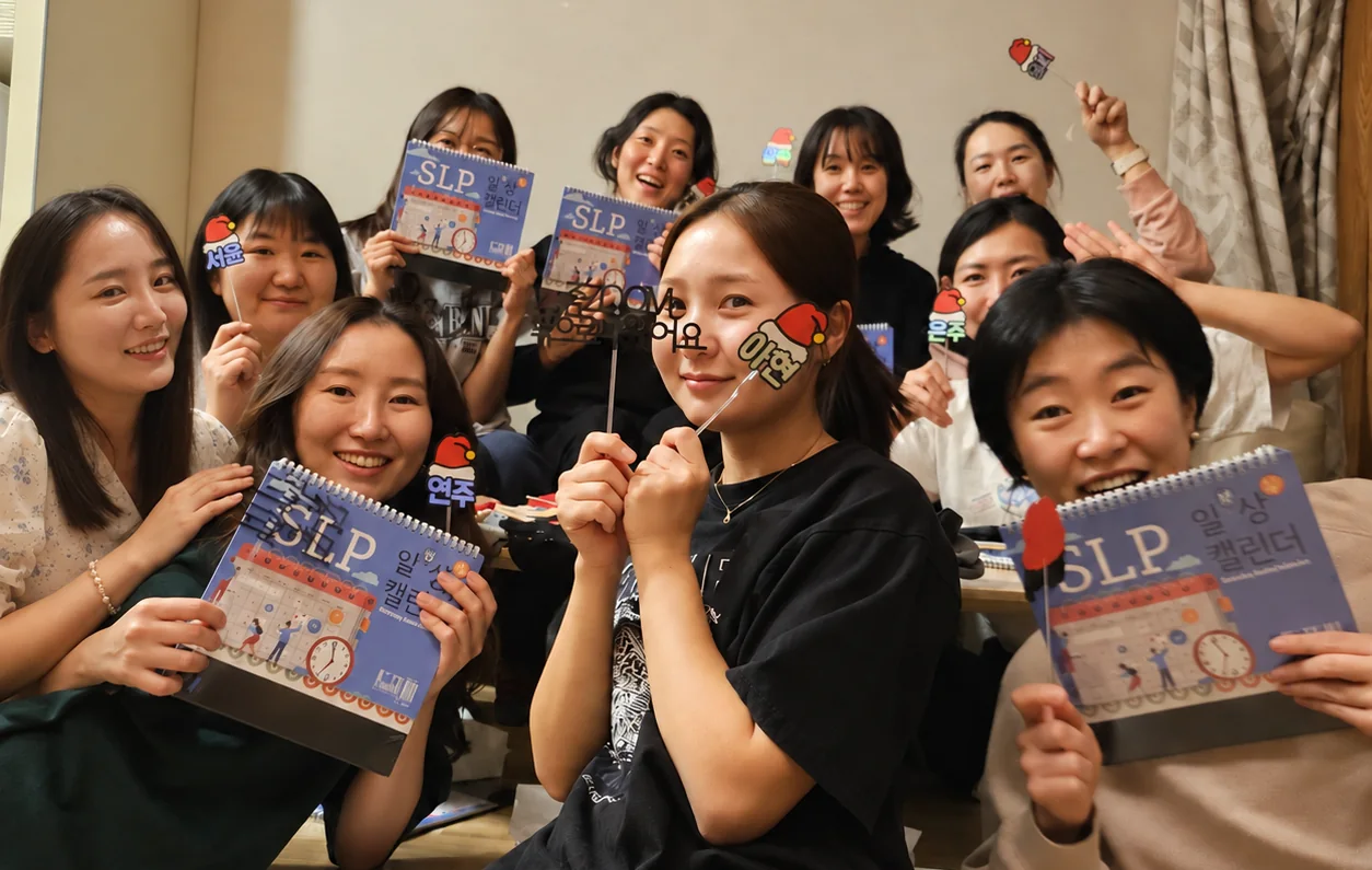 2024년 천안 겨울 워크숍에서 이름 토퍼와 SLP 일상 캘린더를 들고 웃고 있는 라라 크루 선생님들